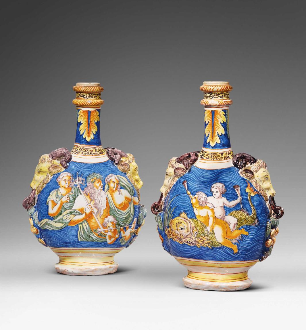 Two earthenware flasks with protruding goat heads as handles. One flask depicts a group of people floating in a body of water with one holding a trident at the center. The other flask depicts two small figures holding horns and riding a sea creature.
