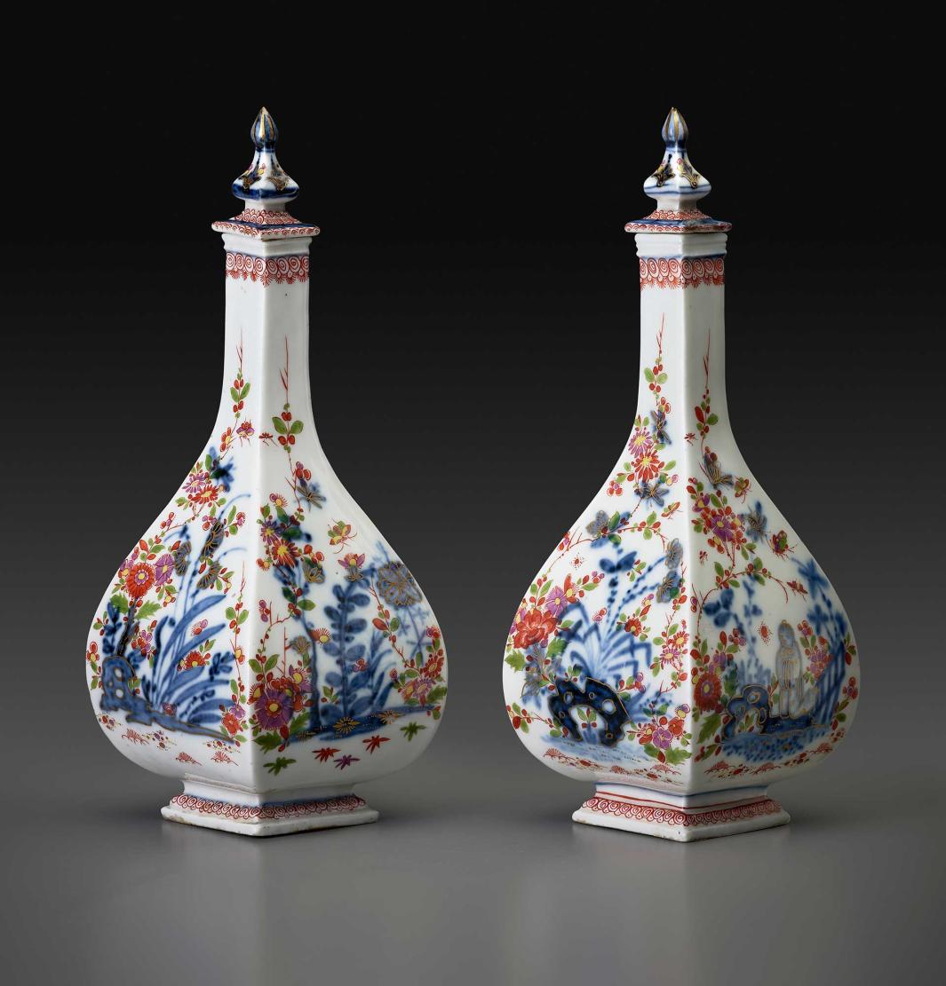 Pair of porcelain four-sided bottles with stoppers.  There are details of flowers and scenes in various colors of blue, red, yellow, and orange.