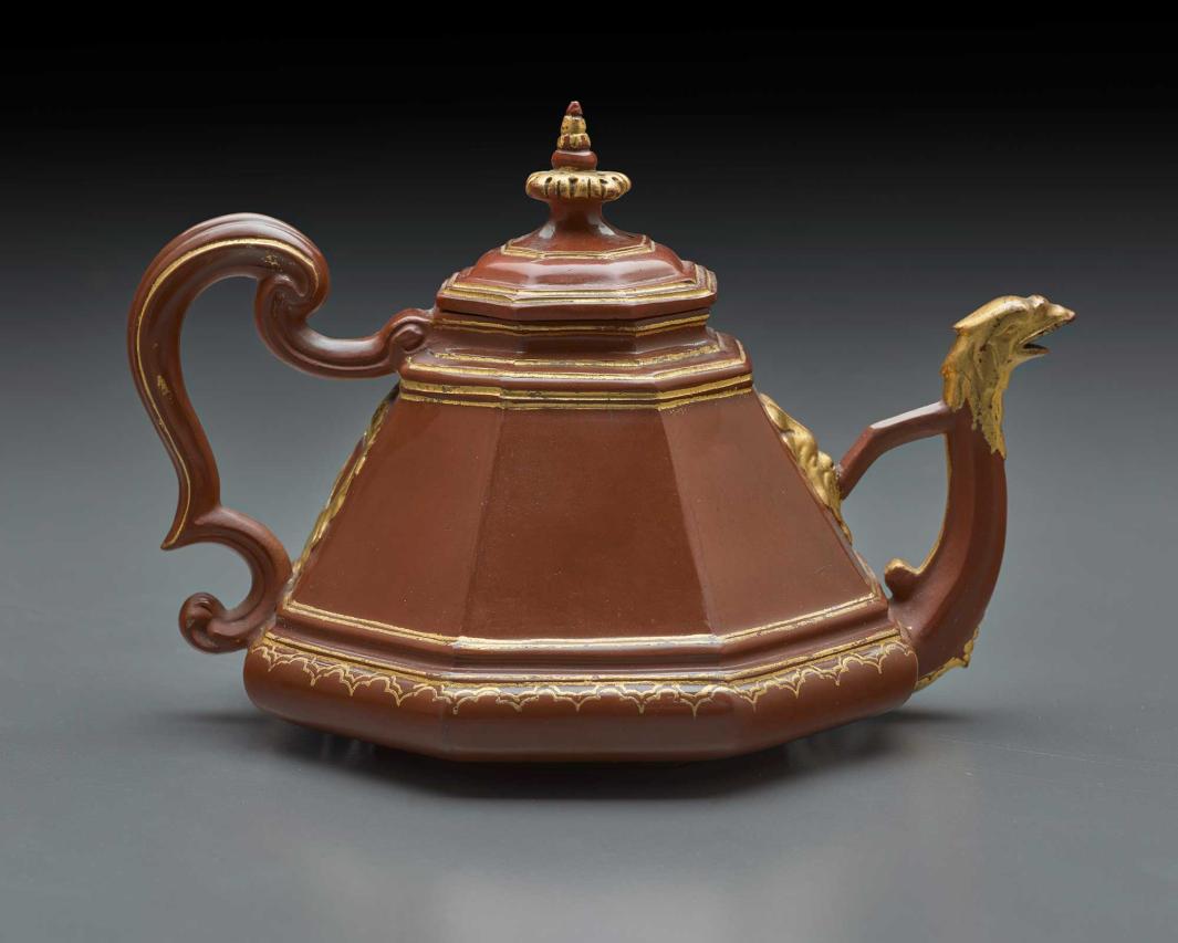 brown teapot in a pyramidal shape, with gold