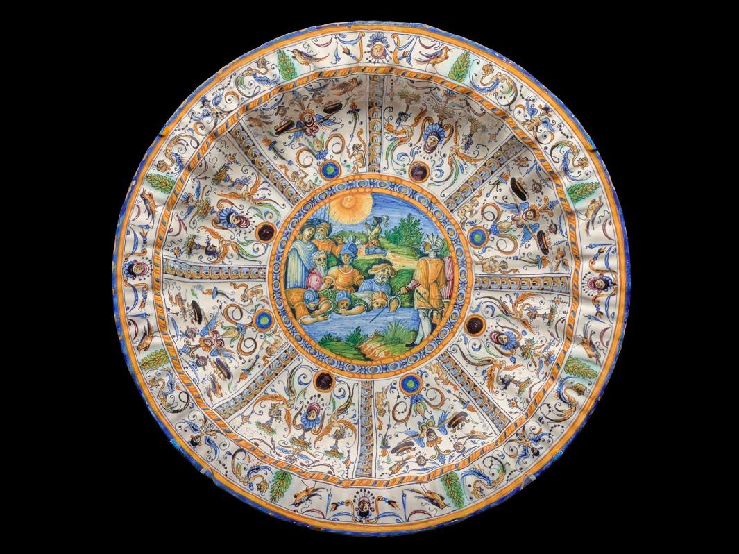 Earthenware dish with a scene of soldiers at a river in the center surrounded by small portraits and floral designs