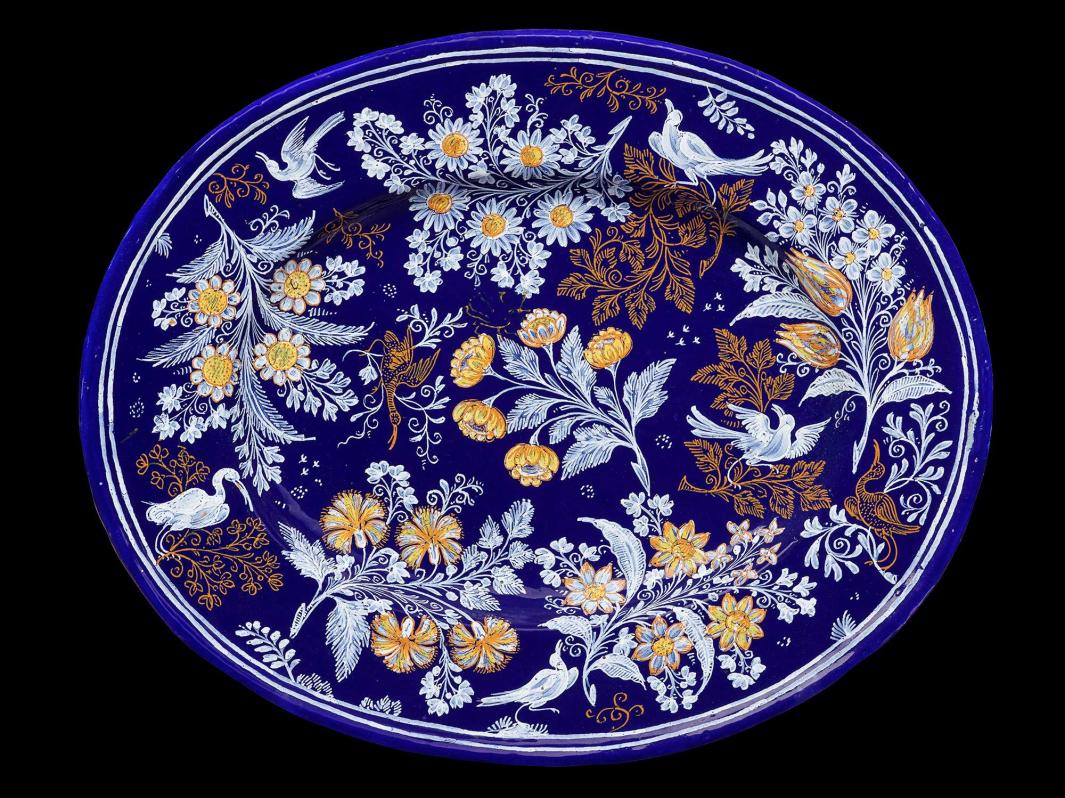 Blue earthenware platter with plants and birds in white and gold
