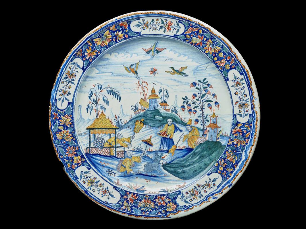 Earthenware platter with a landscape scene with a dragon surrounded by several figures