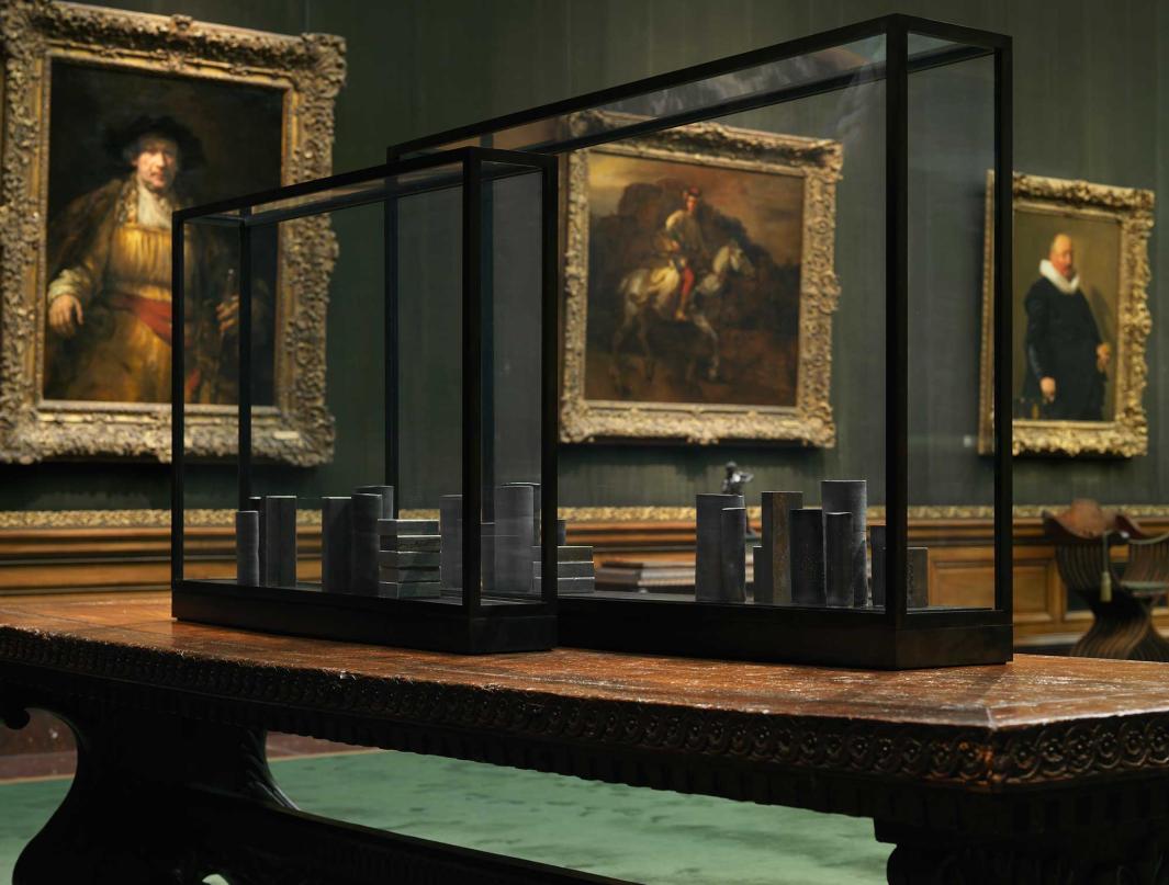 Two black vitrines in the West Gallery containing black porcelain vessels and steel blocks