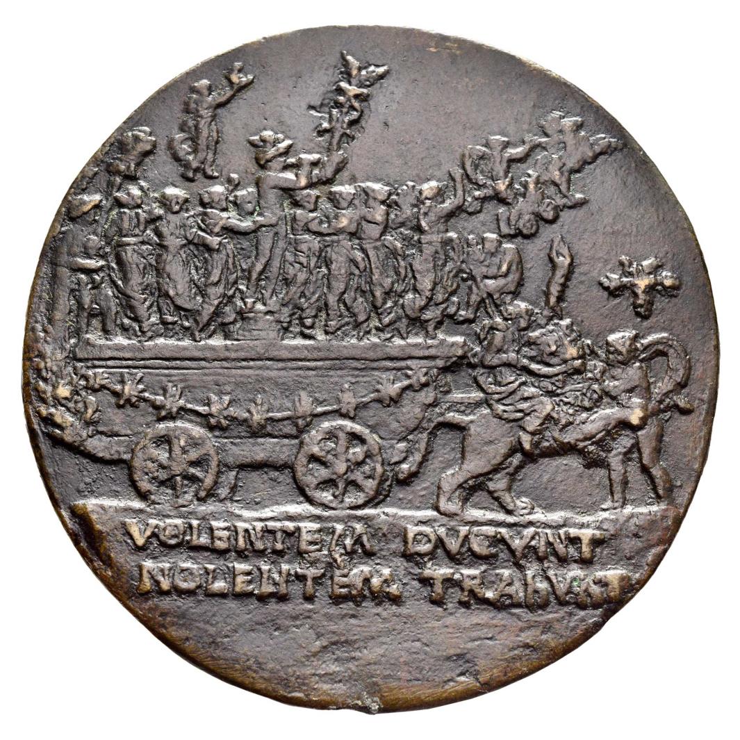 Reverse side of a bronze medal depicting a large cart carrying multiple figures.