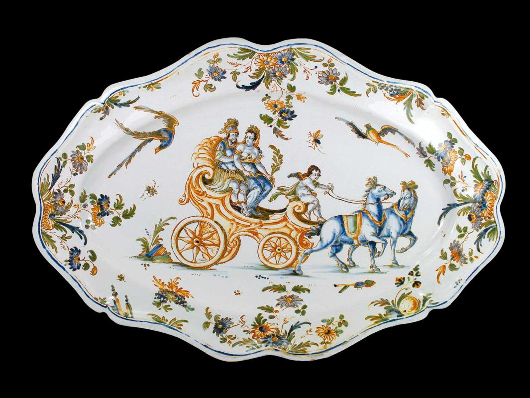 Earthenware platter with a scene of a chariot being pulled by two horses, with two passengers and a driver, and surrounded by flowers, birds and insects.