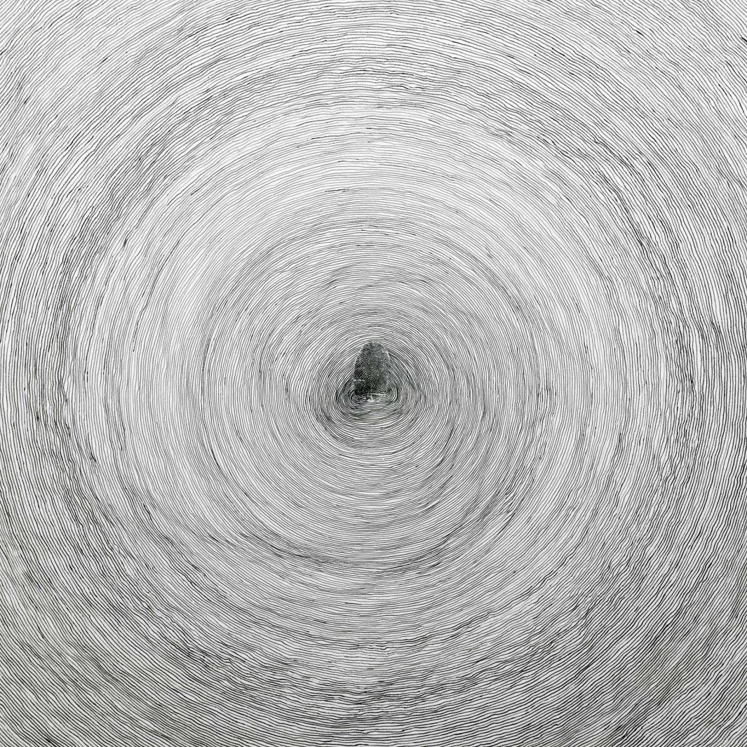 detail of white ceramic disk painted with thin, gray concentric circles and a gray fingerprint at center