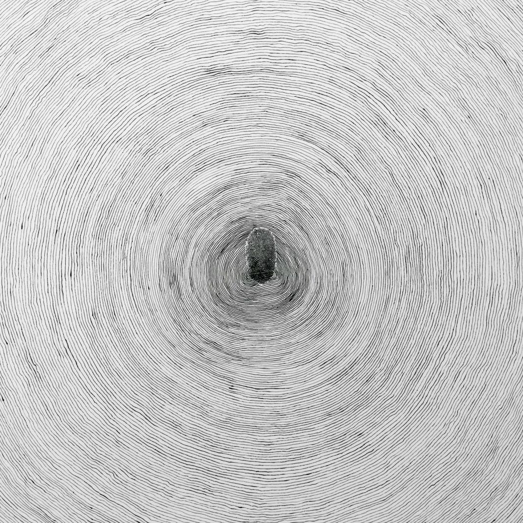 detail of white ceramic disk painted with thin, gray concentric circles and a gray fingerprint at center