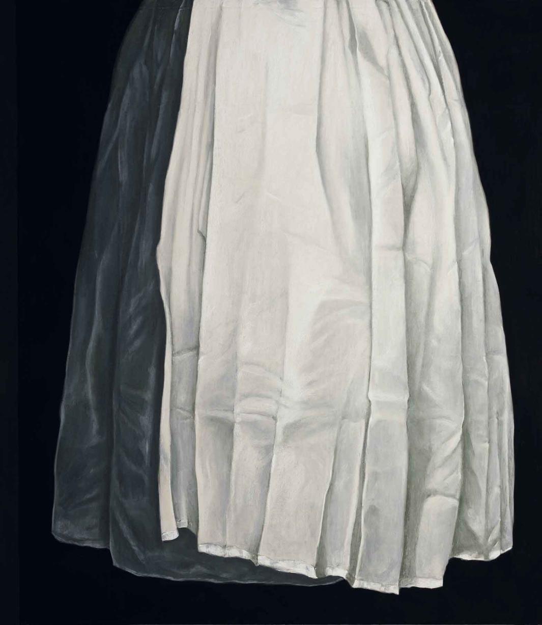 Image of large pleated cloth, one large section white and one small section black, hanging down over a black background