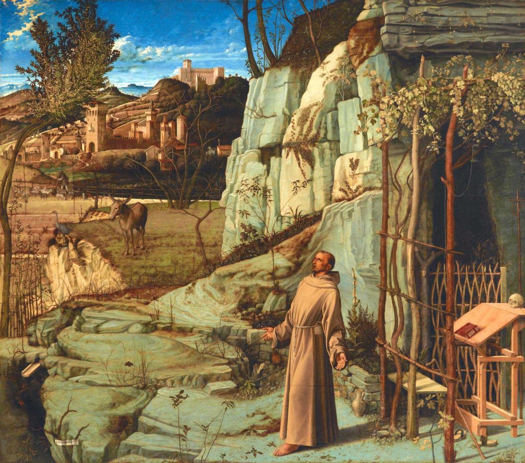 Oil painting of St. Francis dressed in robes in a rocky landscape with animals and a city in the dis