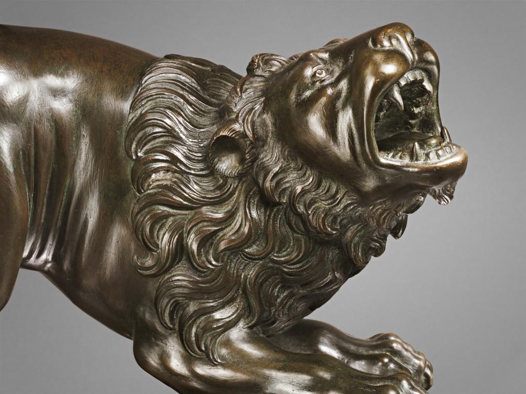 Bronze sculpture of roaring lion, close up of head.