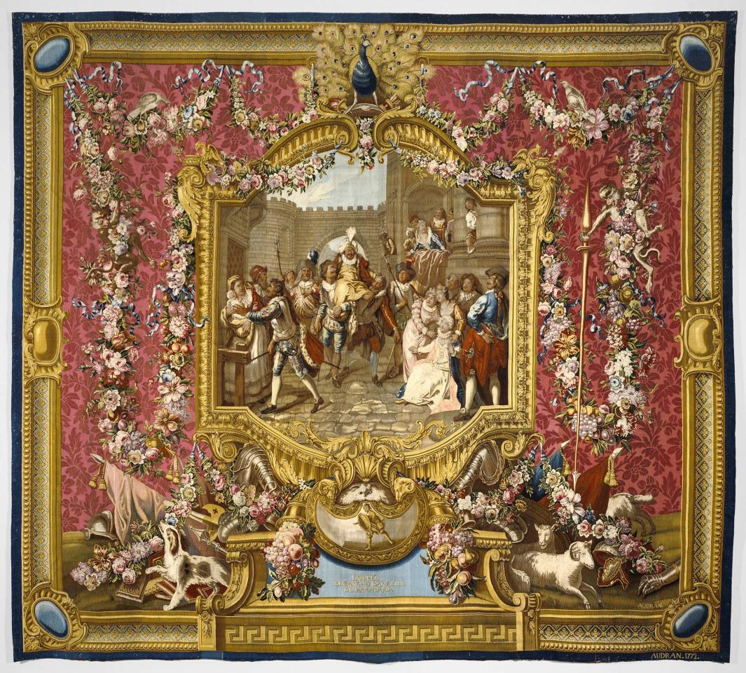 Tapestry of Sancho arriving on the Island of Barataria with townspeople framed by a red, gold, and floral border