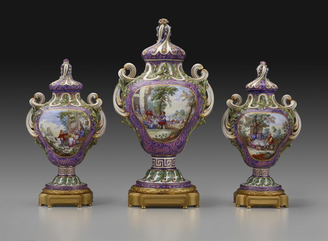 set of three potpourris vases with one larger version, each decorated with figures in a landscape, surrounded by purple and gold