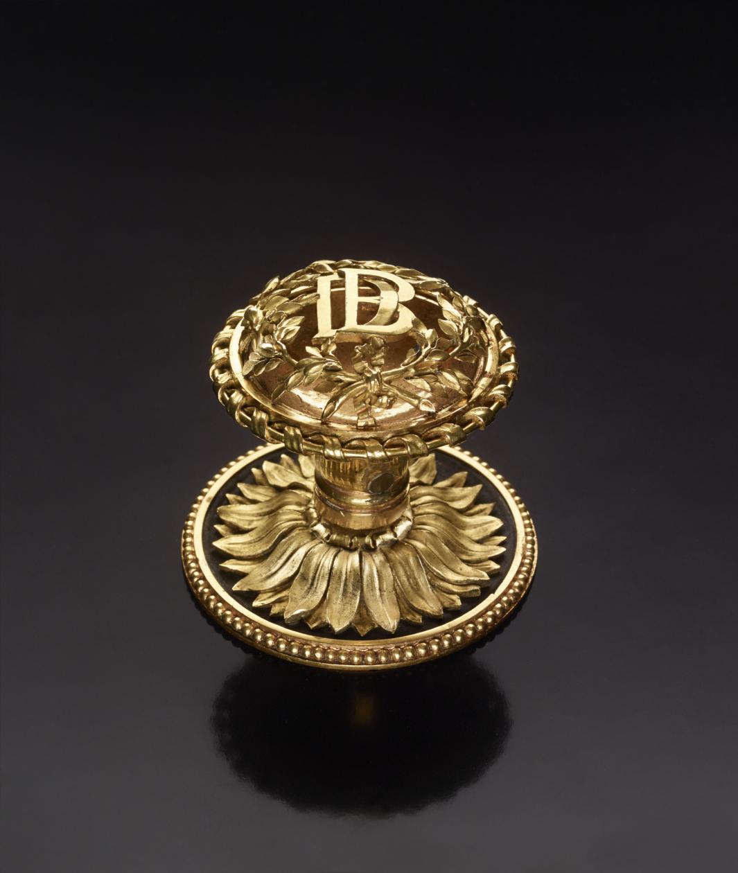 gilt bronze window knob, adorned with overlapping "DB" at its center