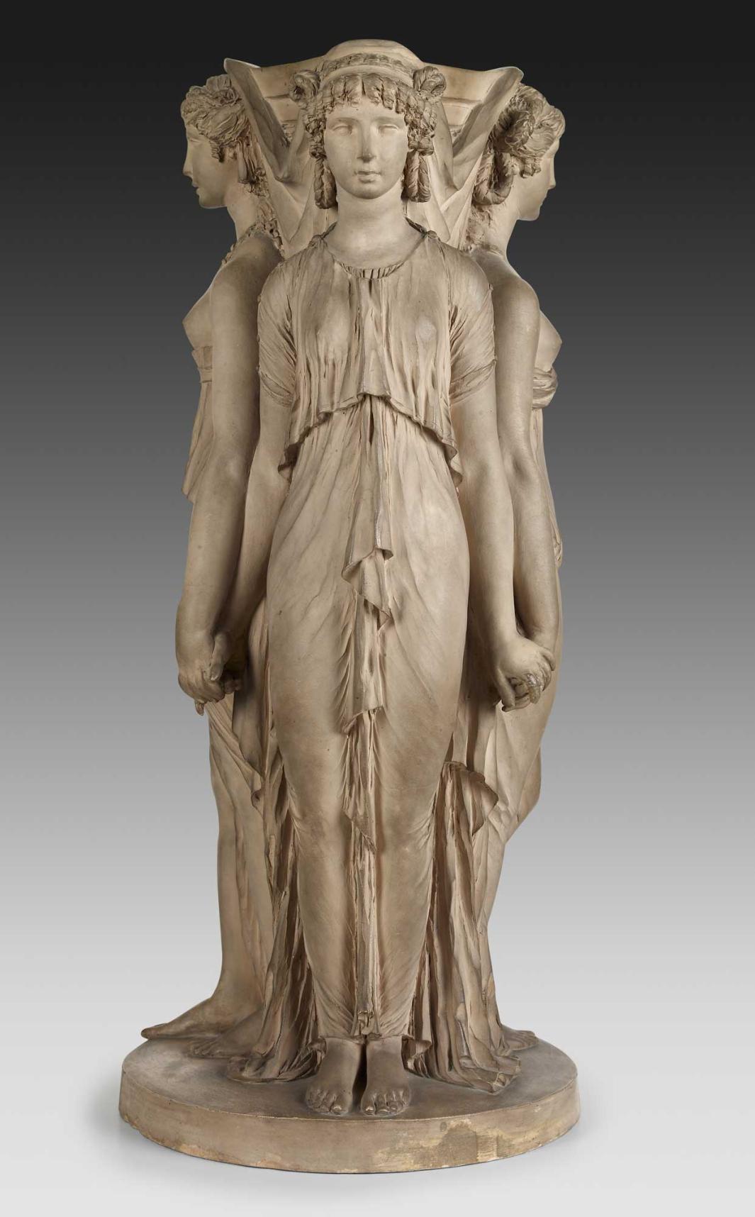 Alternate view of a terracotta statuette of  standing females linking hands around a central column