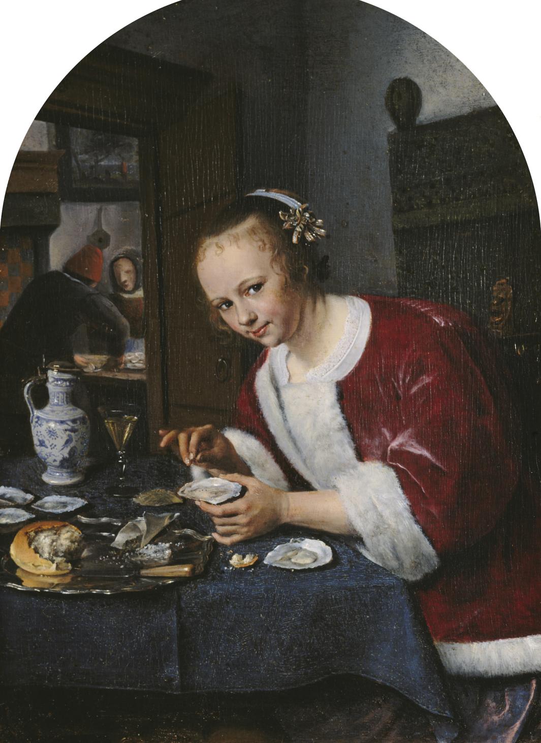 A young woman who leans over a table filled with food and sprinkles salt on an oyster. 
