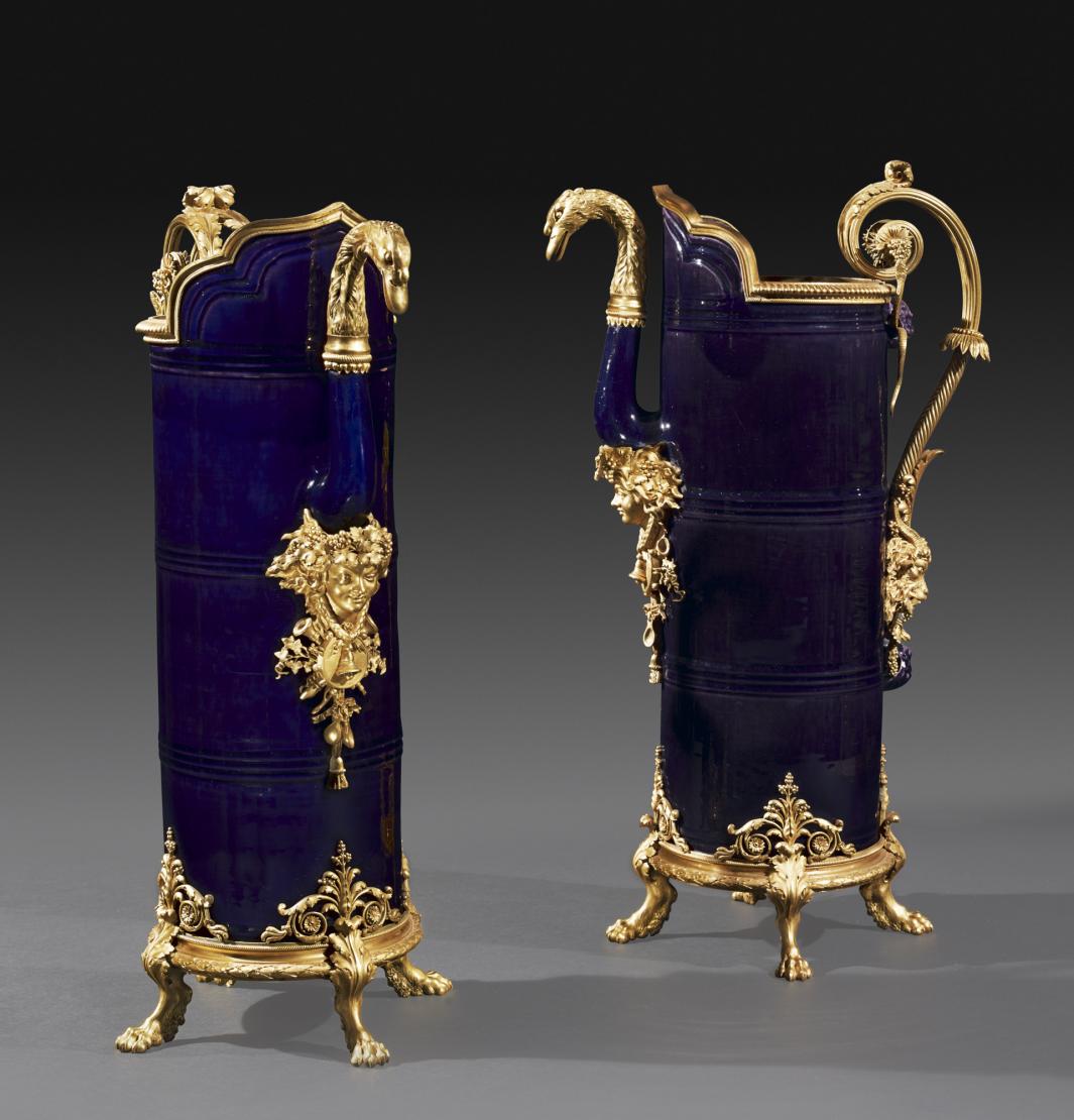 pair of large porcelain jugs with gilt-bronze decorations such as female heads, goat heads and swan head spouts