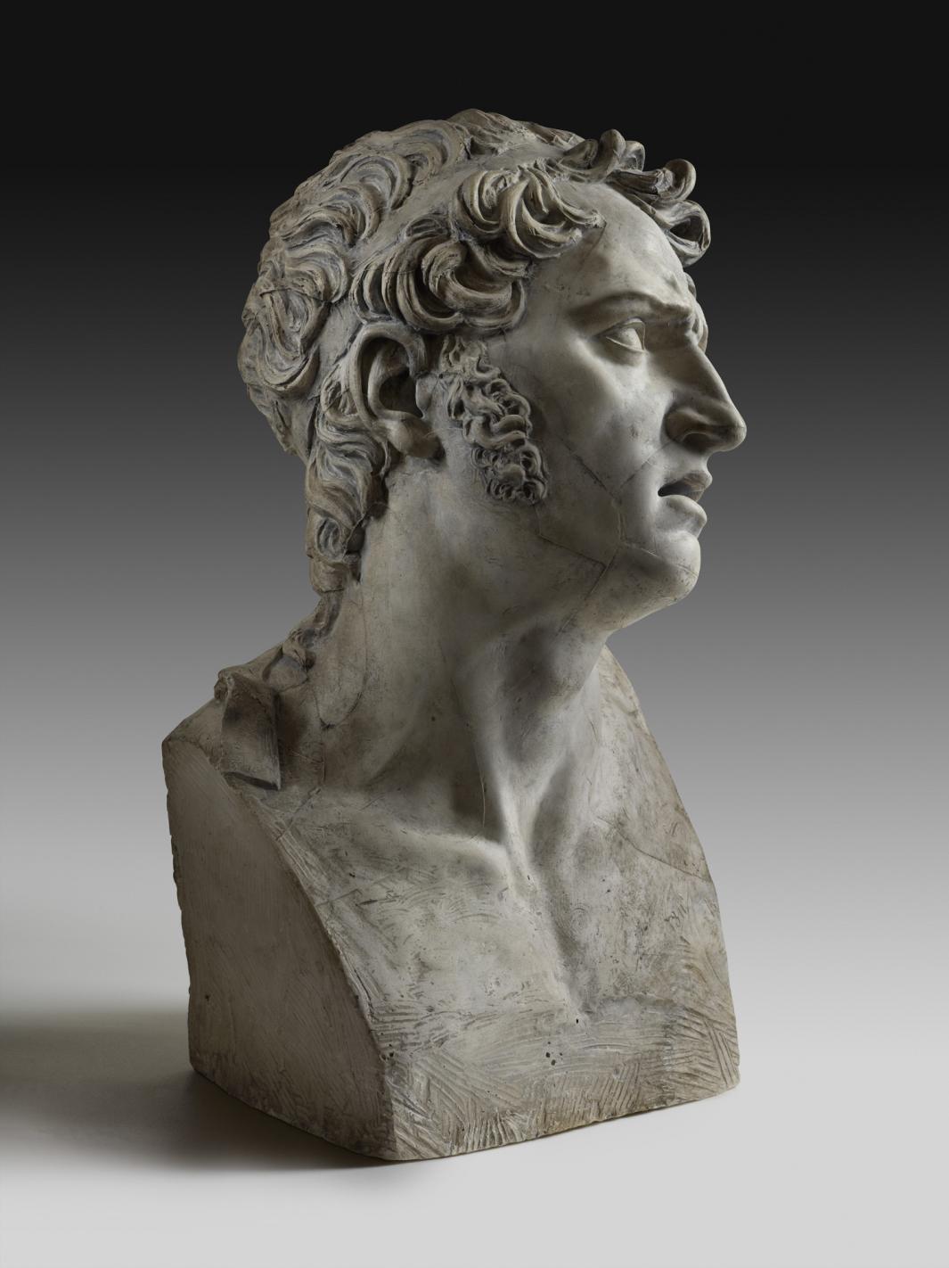 plaster sculpted bust of man, with brow furrowed and head turned (side view)