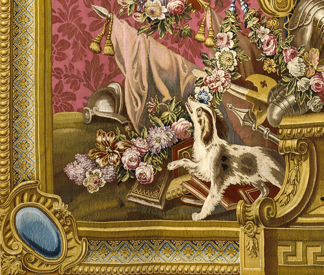 Close-up of tapestry with dog, flowers, textiles, and armor