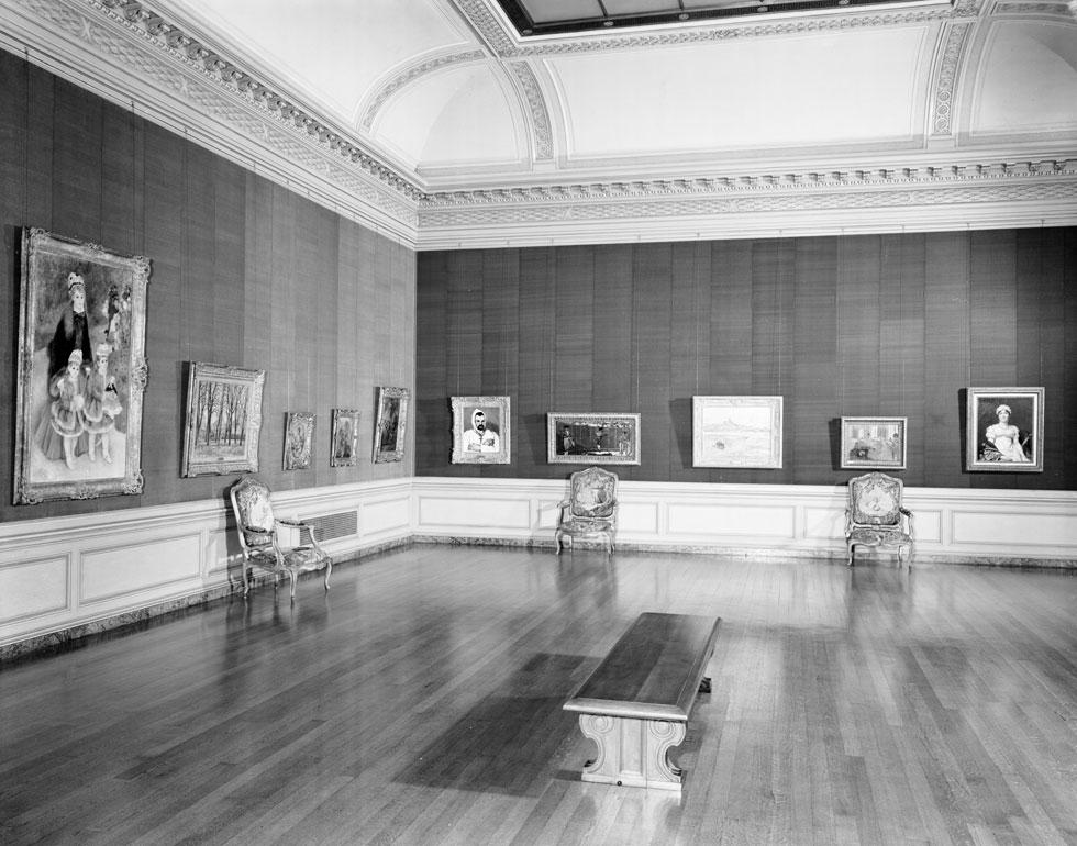 Black and white photograph of the East Gallery of the Frick Collection in 1942 depicts war-time arrangement of collection.