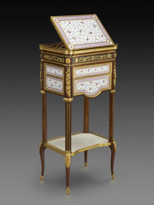 Photograph of small eighteenth century writing table made of oak and maple, decorated with plaques of porcelain and gilt bronze.