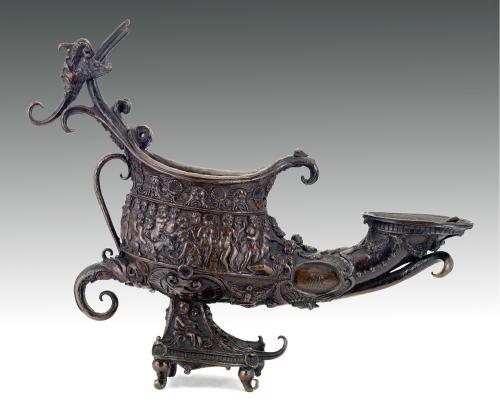 intricately designed bronze oil lamp, with cast figures depicted