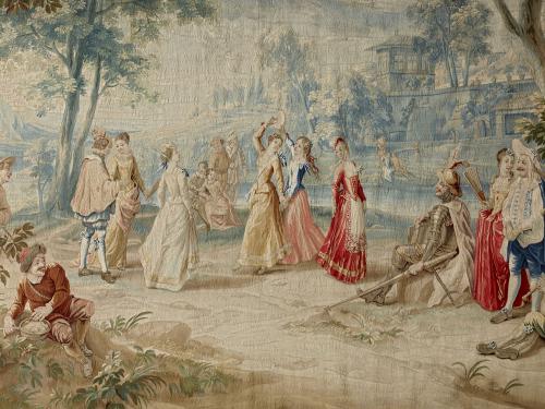 detail of tapestry depicting guests at a wedding in 18th century dress dancing outdoors.