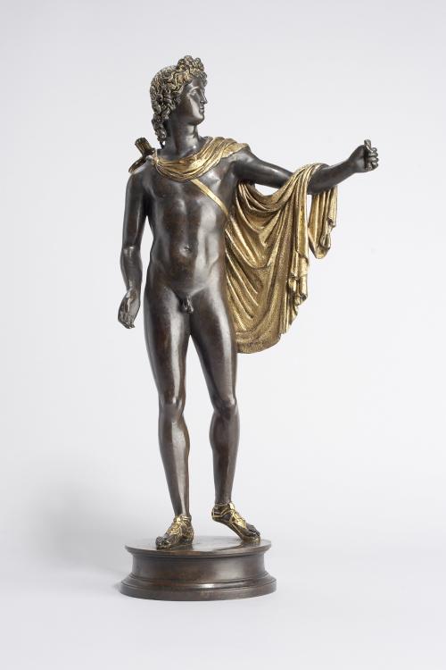 bronze sculpture of standing male mythical figure with arm raised and golden cape