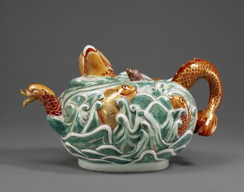 Green porcelain teapot with orange fish decorations.