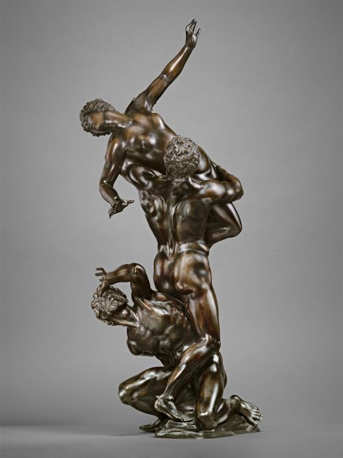 Bronze sculpture of a male figure, abducting a female figure, with a male figure at his feet.