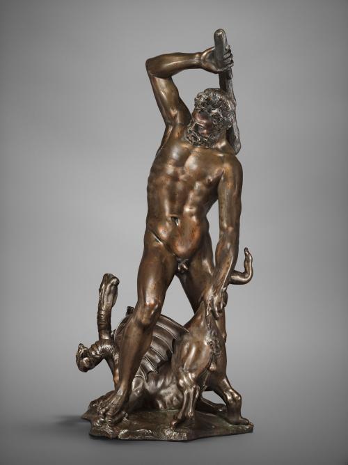 Bronze sculpture of a male figure attacking a monster.