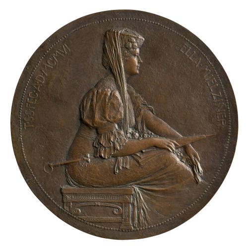 Bronze portrait medal of Ella Mielziner seated on a bench, with hair worn pinned beneath a pillbox hat (decorated with three flowers) draped with a long veil, wearing a long dress with a lace or embroidery neck and elbow-length, leg-of-mutton sleeves (bound tight around the upper arm), holding a parasol in her lap and a pair of gloves in her hand 