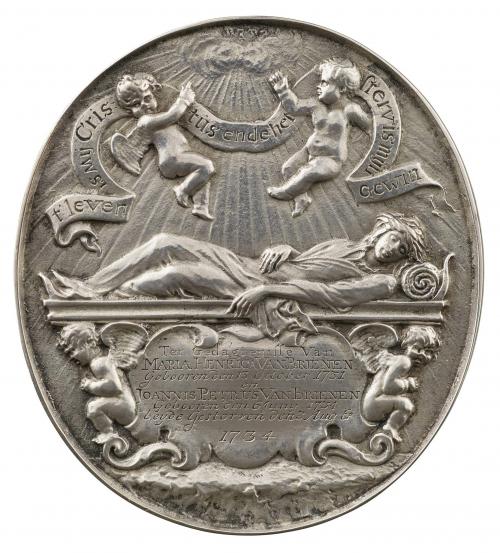 Silver medal depicting two flying genii, nude, pointing toward the clouds from which rays of sunlight stream. They support a banner; below, a woman crowned with laurels and wrapped in a shroud, her eyes closed and head supported by a roll of cloth, reclines upon a sarcophagus, fronted by a cartouche flanked by genii