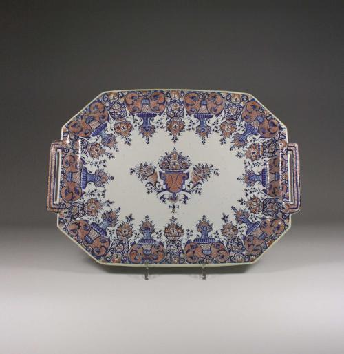 Earthenware tray with a floral motif in blue and orange on a white background.