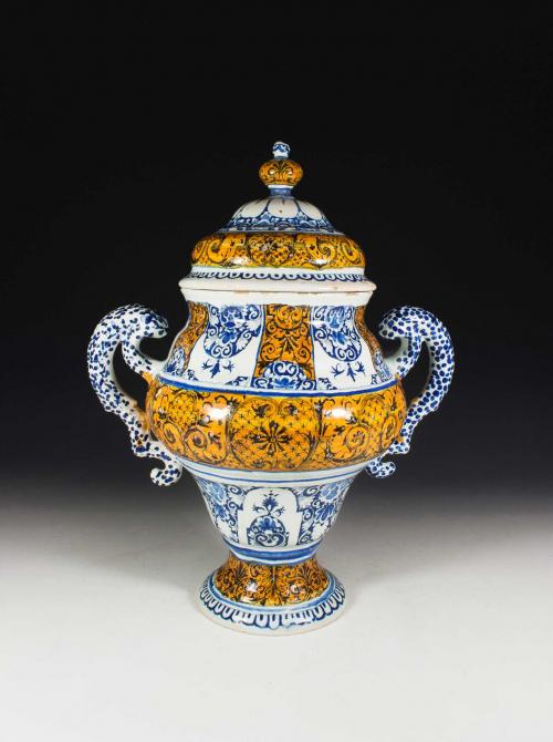 Earthenware vase with floral motif in blue on white with large sections of black on yellow.