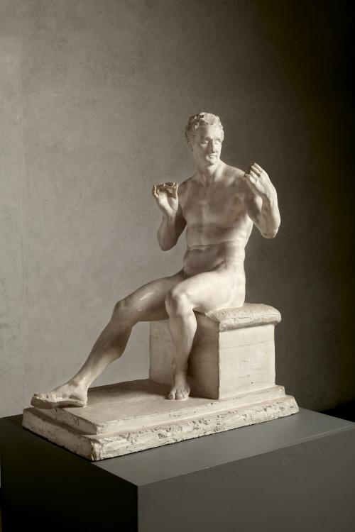 sculpture of nude male seated 