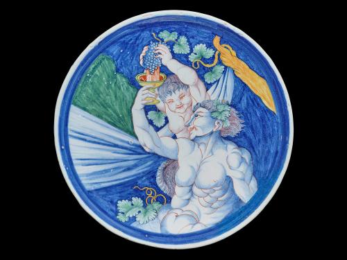 Earthenware dish depicting two figures turning a bundle of grapes into wine