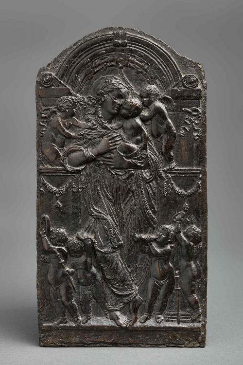 Bronze relief of the Virgin and Child standing in a niche and surrounded by angels.