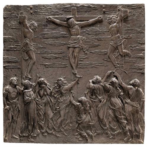 Bronze relief sculpture of Christ being crucified alongside two other men, with a crowd gathered beneath them.