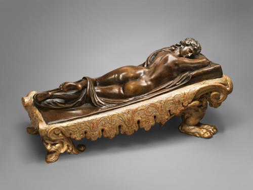 Bronze sculpture on wooden base of a sleeping nude figure.