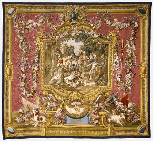 Tapestry of dogs and people hunting a boar and Sancho climbing a tree, all framed by a red, gold, and floral border