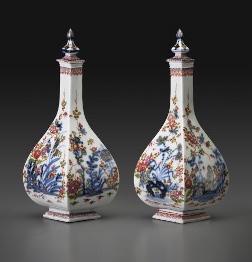 photo of two white porcelain bottles with stoppers, decorated with flowers