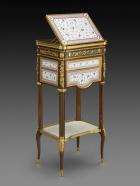 Photograph of small eighteenth century writing table made of oak and maple, decorated with plaques of porcelain and gilt bronze.