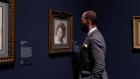 video still of man in gallery viewing drawing of woman's head