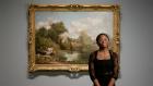 video still of woman standing in front of a painting in a gallery