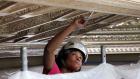 Woman repairing ceiling