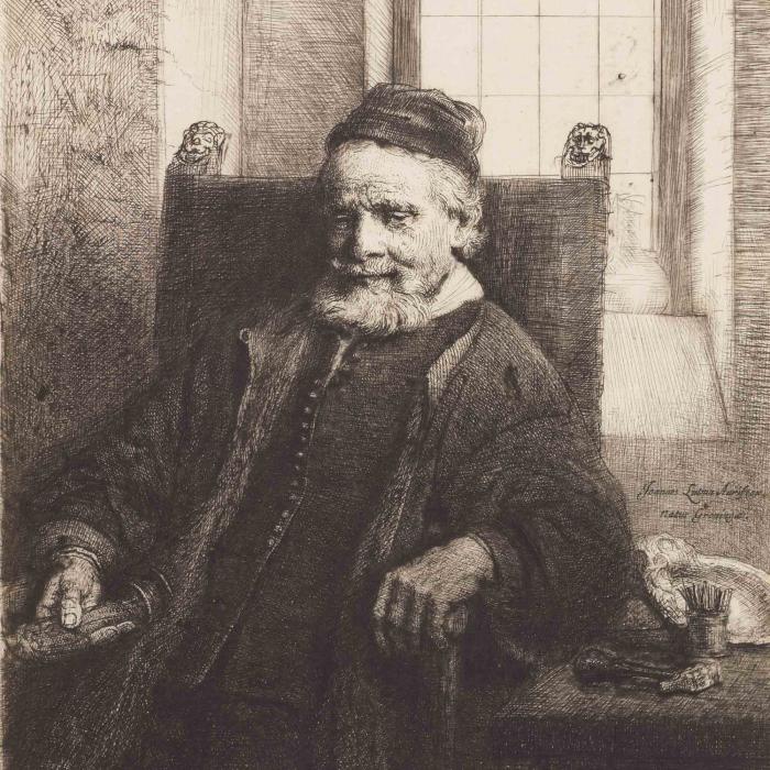 portrait of a bearded old man wearing a hat seated in a chair.
