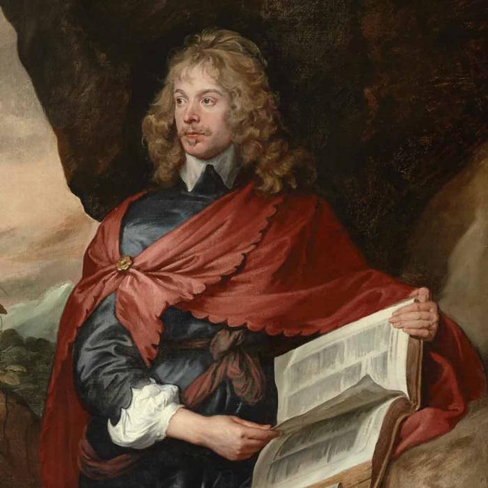 man with curly blond hair holding a book