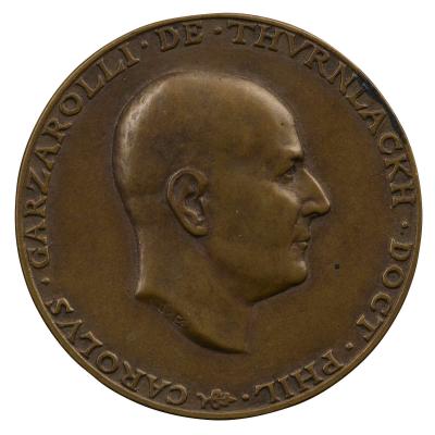Copper medal of a man in profile to the right