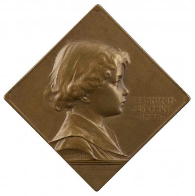 Copper medal with a boy in profile to the right