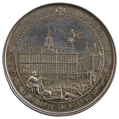 Silver medal depicting Mercury, god of Commerce, flying above the new Town Hall holding the caduceus and a hat signifying Liberty. The Nieuwe Kerk to the right, Amphion seated in the foreground, and the arms of Amsterdam. In the middle ground, a crowd of onlookers.